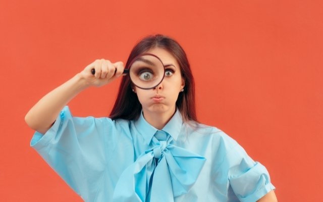 a girl looking through a magnifying glass with critical eyes