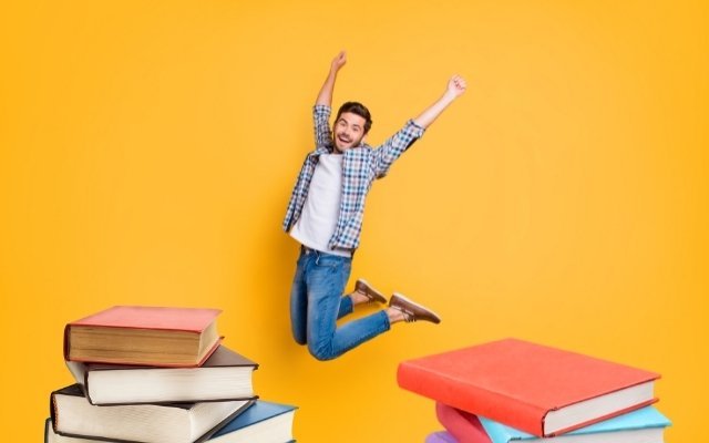 a man jumping high in the air after finishing assignment of reading books