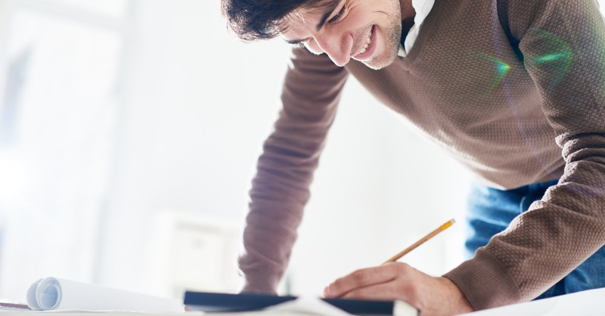 a man enjoying his work and writing something on paper