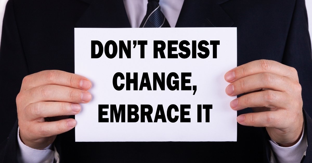 a manager holding a messge that says don't resist change embrace it