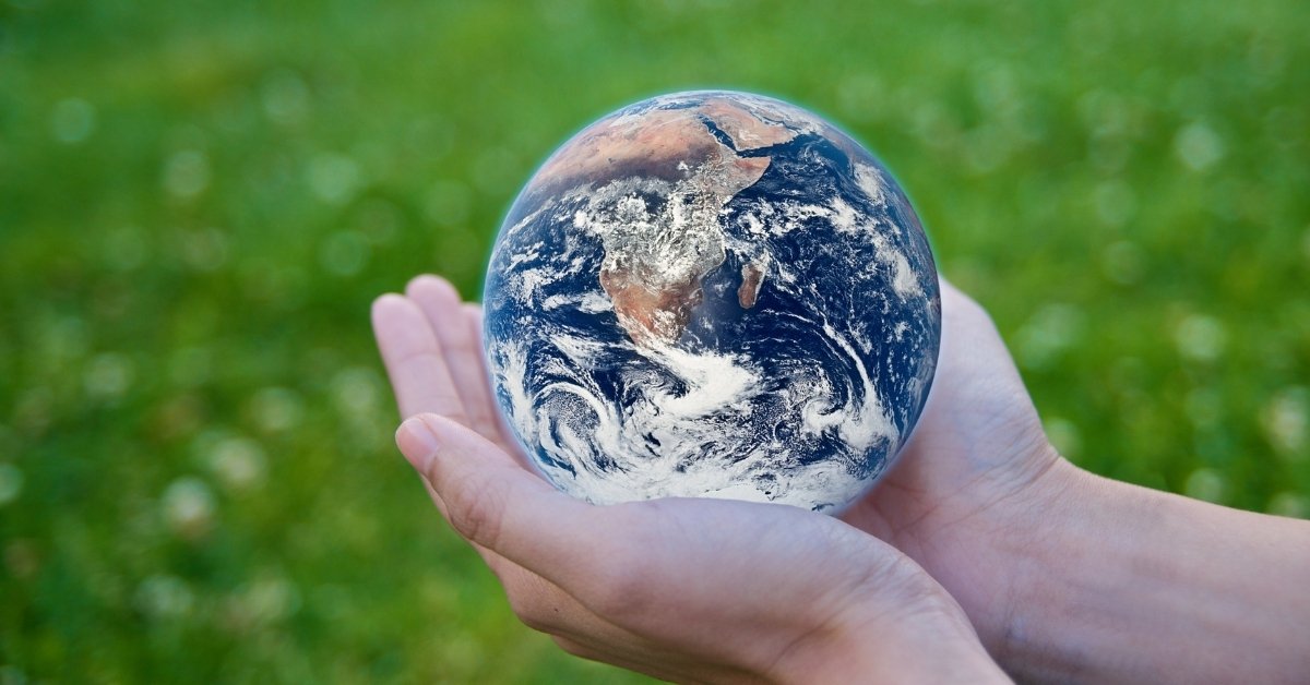 a person holding the planet earth with both of his hands 